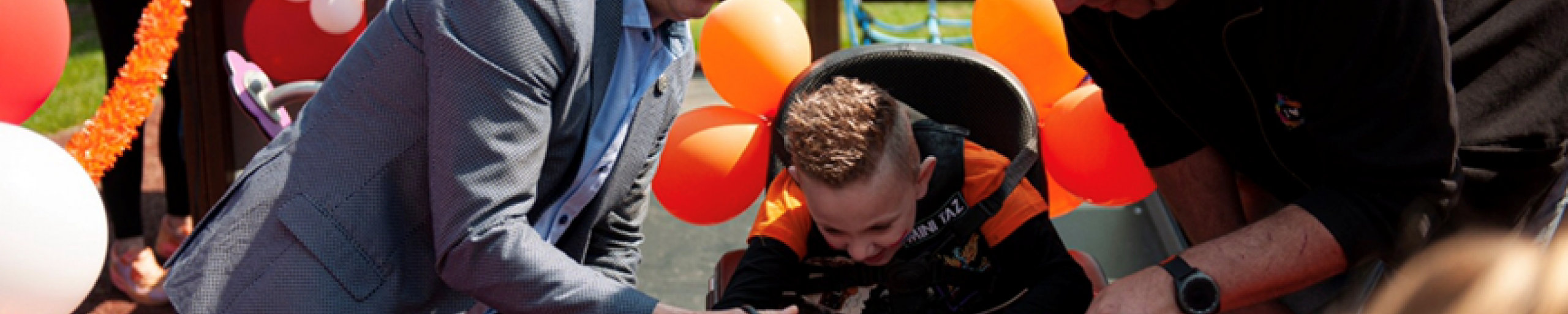 Wethouder Bart Smeets knipt het lintje door samen met Devann en de speeltuinvoorzitter