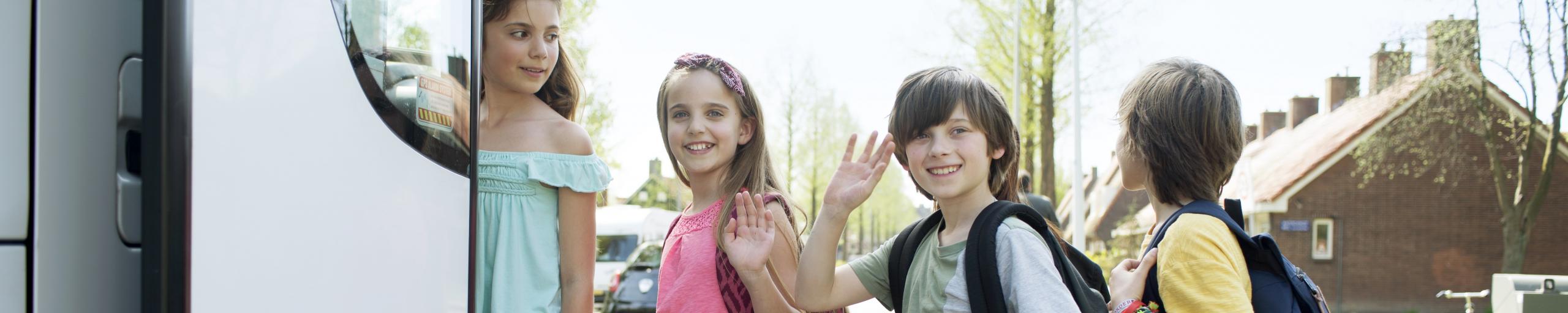 4 kinderen stappen in de bus