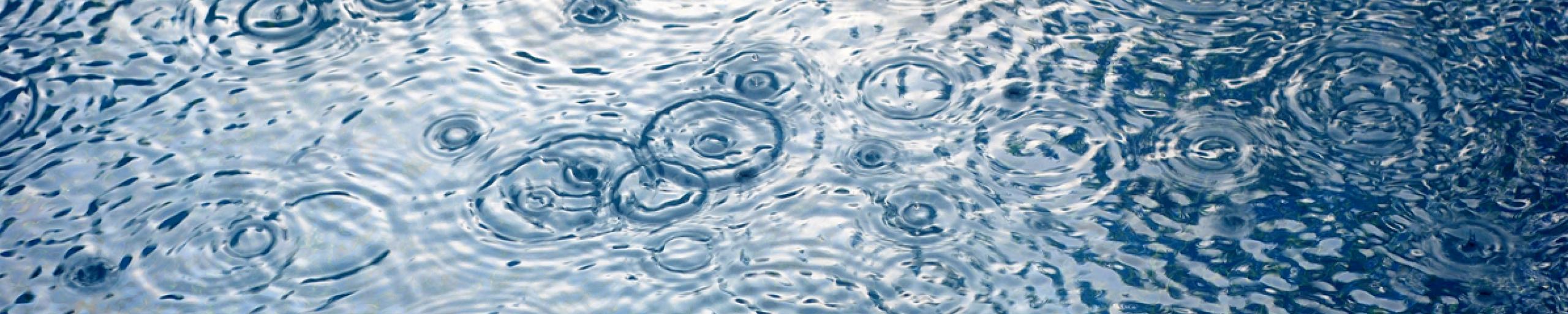 wateroppervlak met kringen van regendruppels