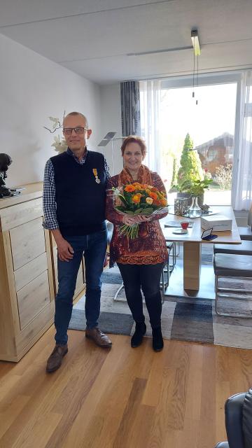 Jo Coenen met het Lintje en zijn echtgenote met bloemen