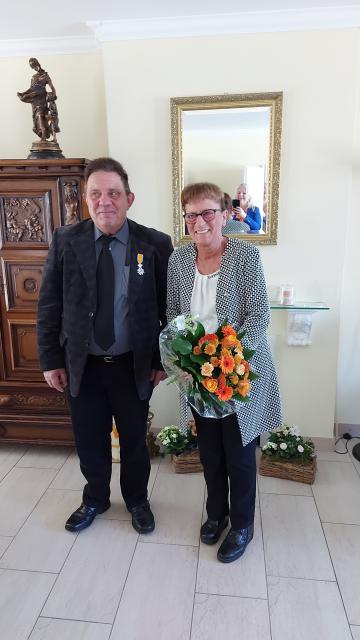 de heer Lei van Kan met Lintje en zijn echtgenote met boeket bloemen